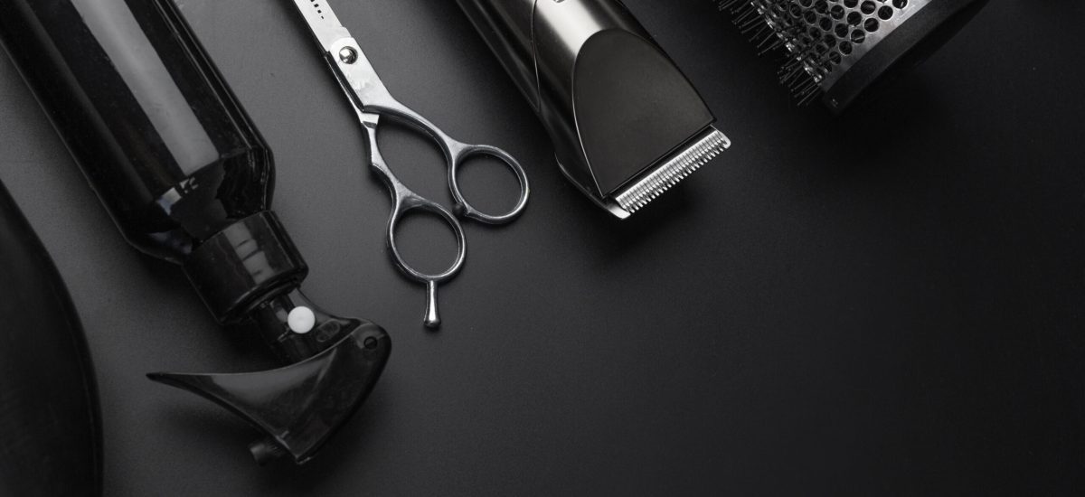 Barbershop concept. Hairdressing tools on dark background top view space for text. Hair extensions, materials and cosmetics, hair care, wig. Hairstyle, haircut in salon